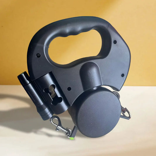 Black retractable dog leash on a beige surface with a yellow background